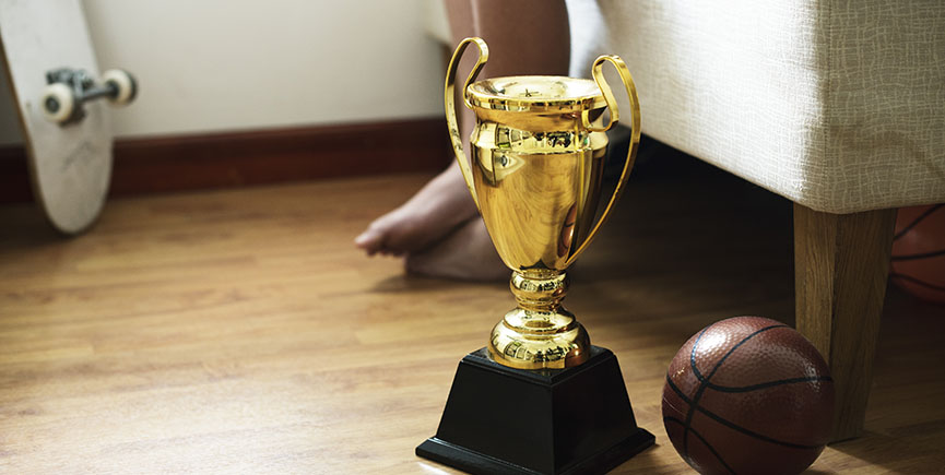 Closeup of trophy on the bedroom floor with basketball