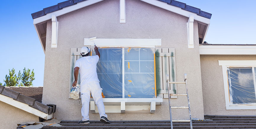 Busy House Painter Painting the Trim And Shutters of A Home.