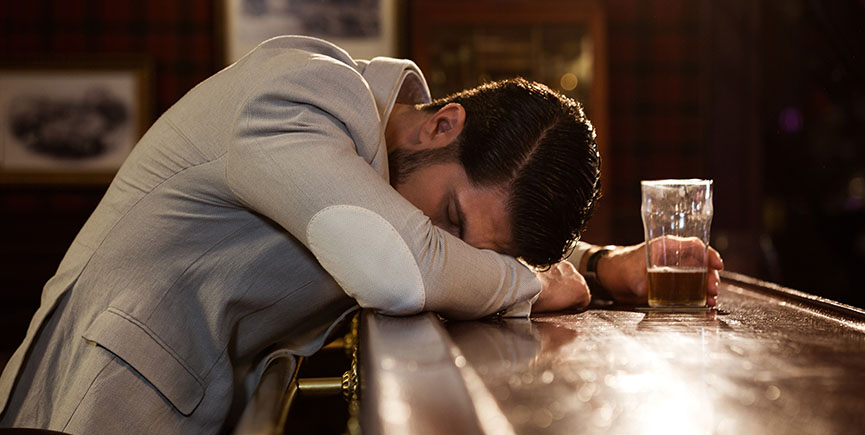 Drunk man sleeping on a pub counter