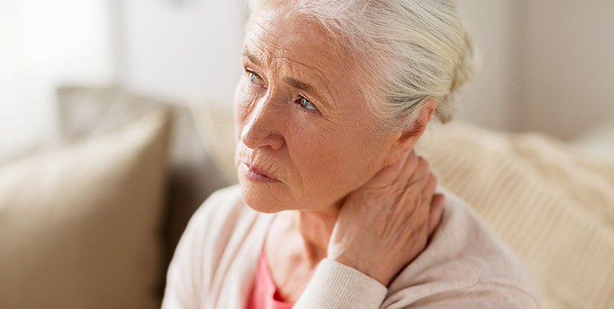 senior woman suffering from neck pain at home