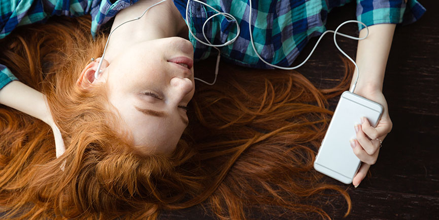 Woman lying on floor and listening to music